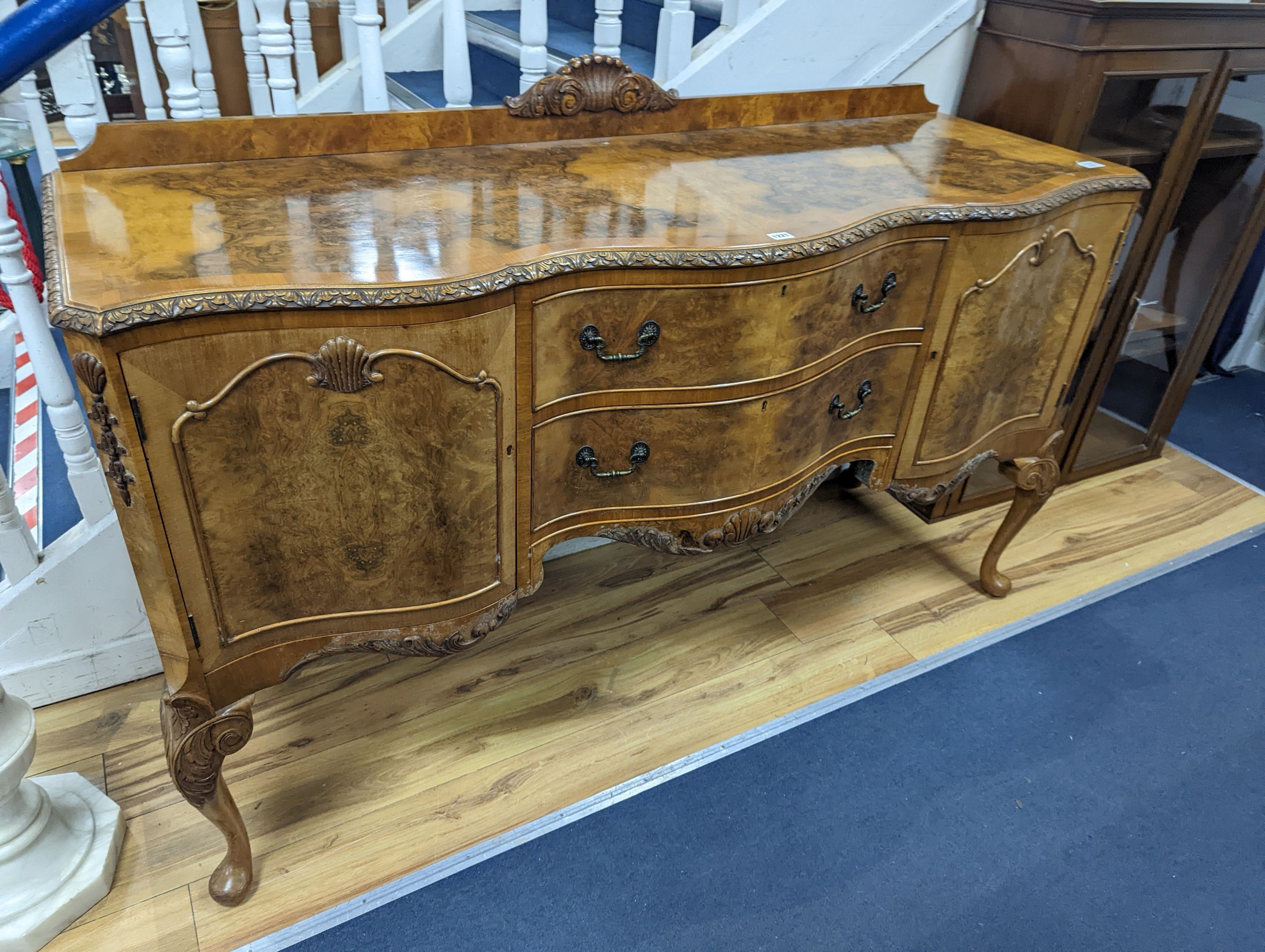 A Queen Anne revival burr walnut dining suite, comprising serpentine sideboard, length 168cm, depth 56cm, height 98cm, extending dining table, 210cm extended, one spare leaf, width 90cm, height 75cm and eight chairs, two